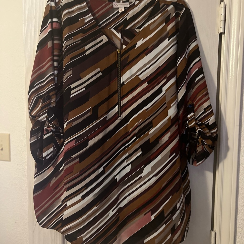 Multi warm colors with zipper front and button up sleeves or wear long.